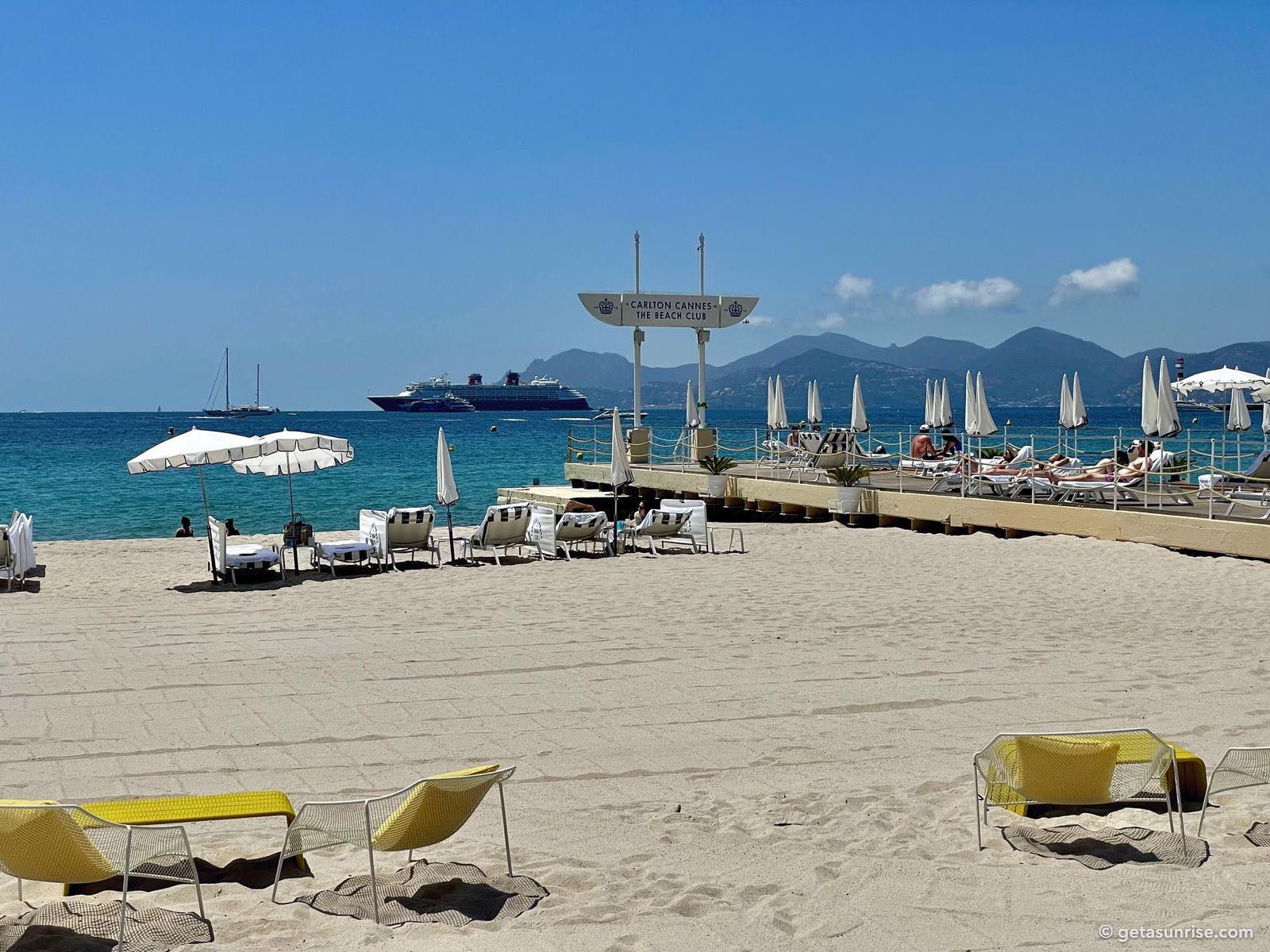 Carlton beach in Cannes with the pier, a cruise ship and the Esterel mountains in the background